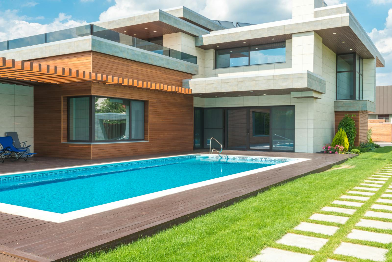 A stunning modern house with a spacious pool and green garden, ideal for relaxation.